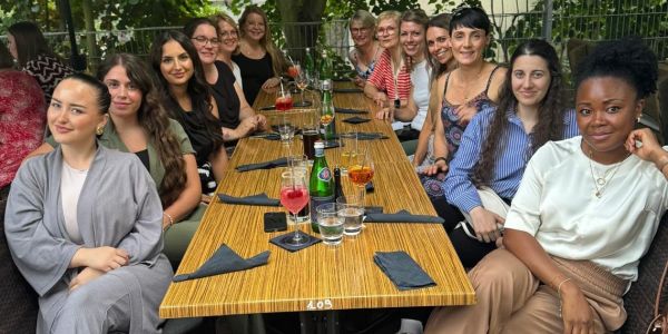 das Praxisteam sitzt zusammen mit Fr. Dr. Ofner-Martin und den anderen Zahnärztinnen im Biergarten an einem Tisch, darauf stehen Getränke